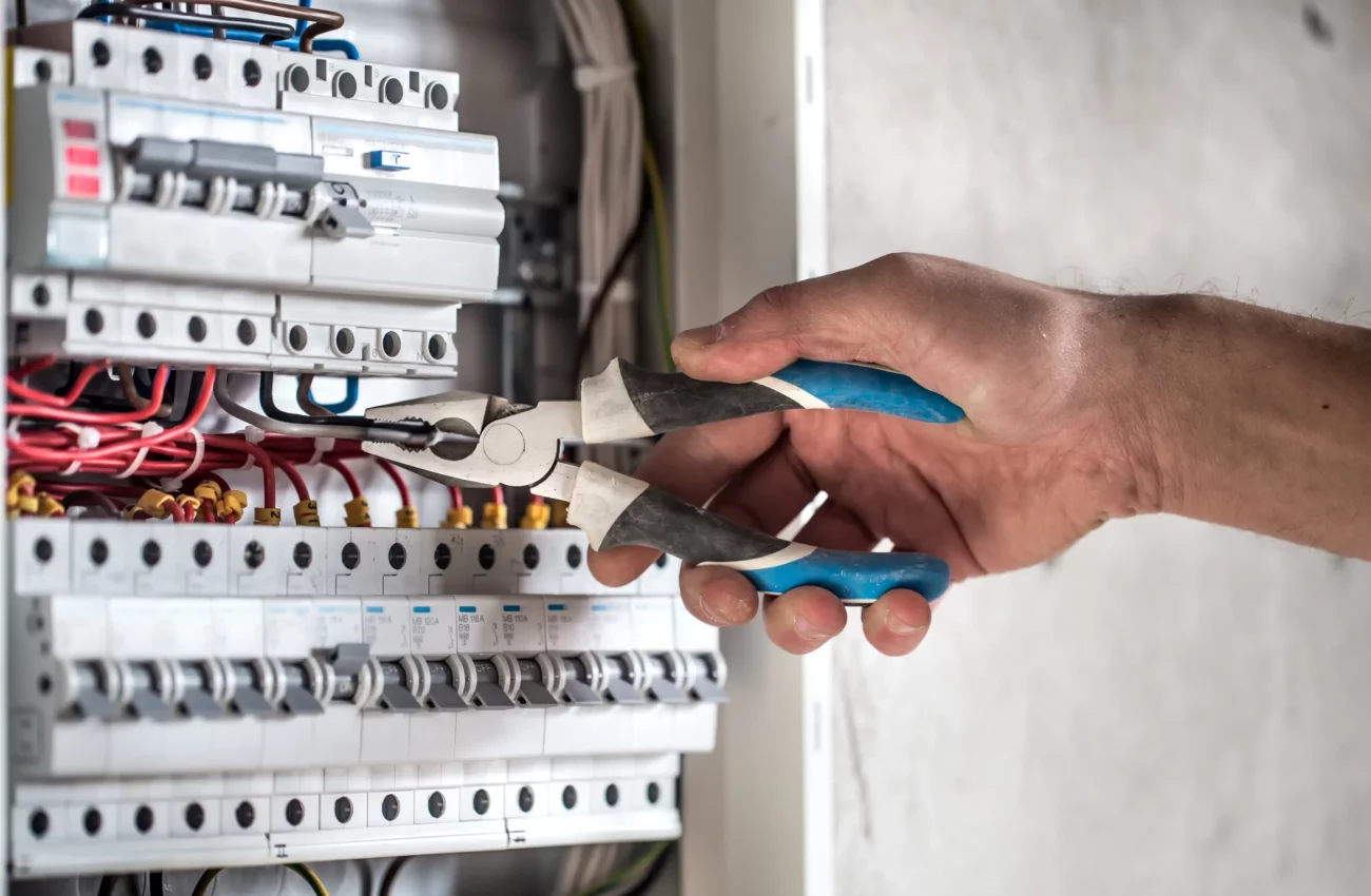 electrical-technician-working-switchboard-with-fuses-scaled-1.webp