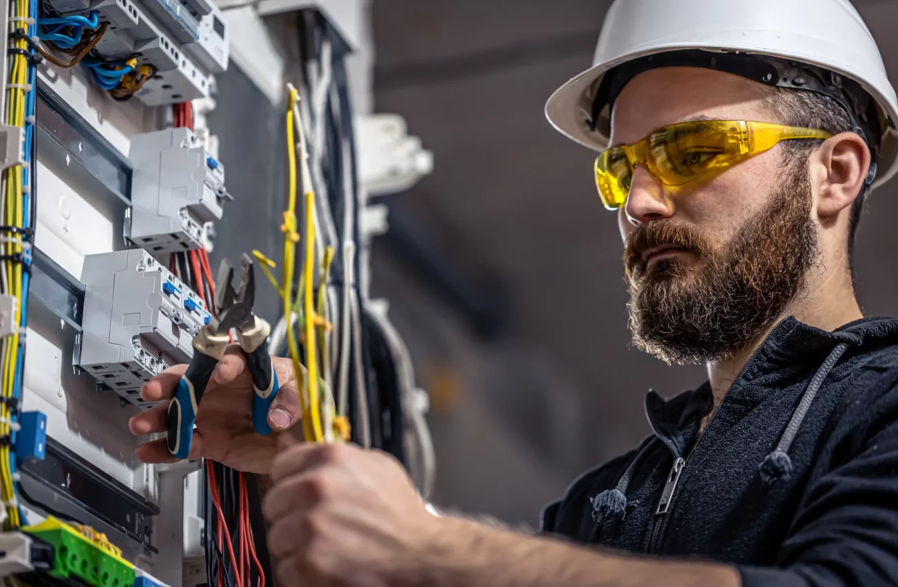 male-electrician-works-switchboard-with-electrical-connecting-cable-scaled-1.webp